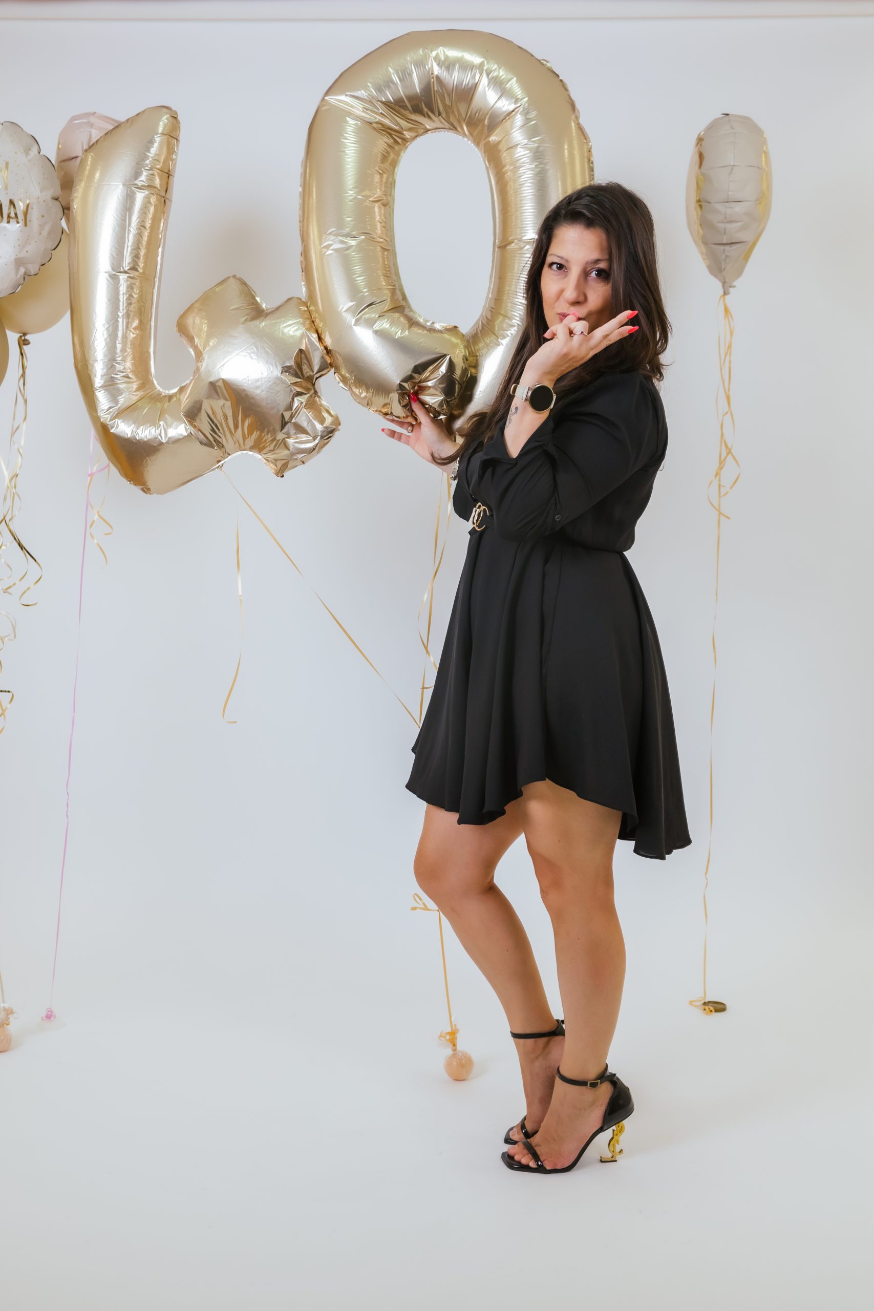 Modna foto sesija devojke u crnoj haljini sa balonima