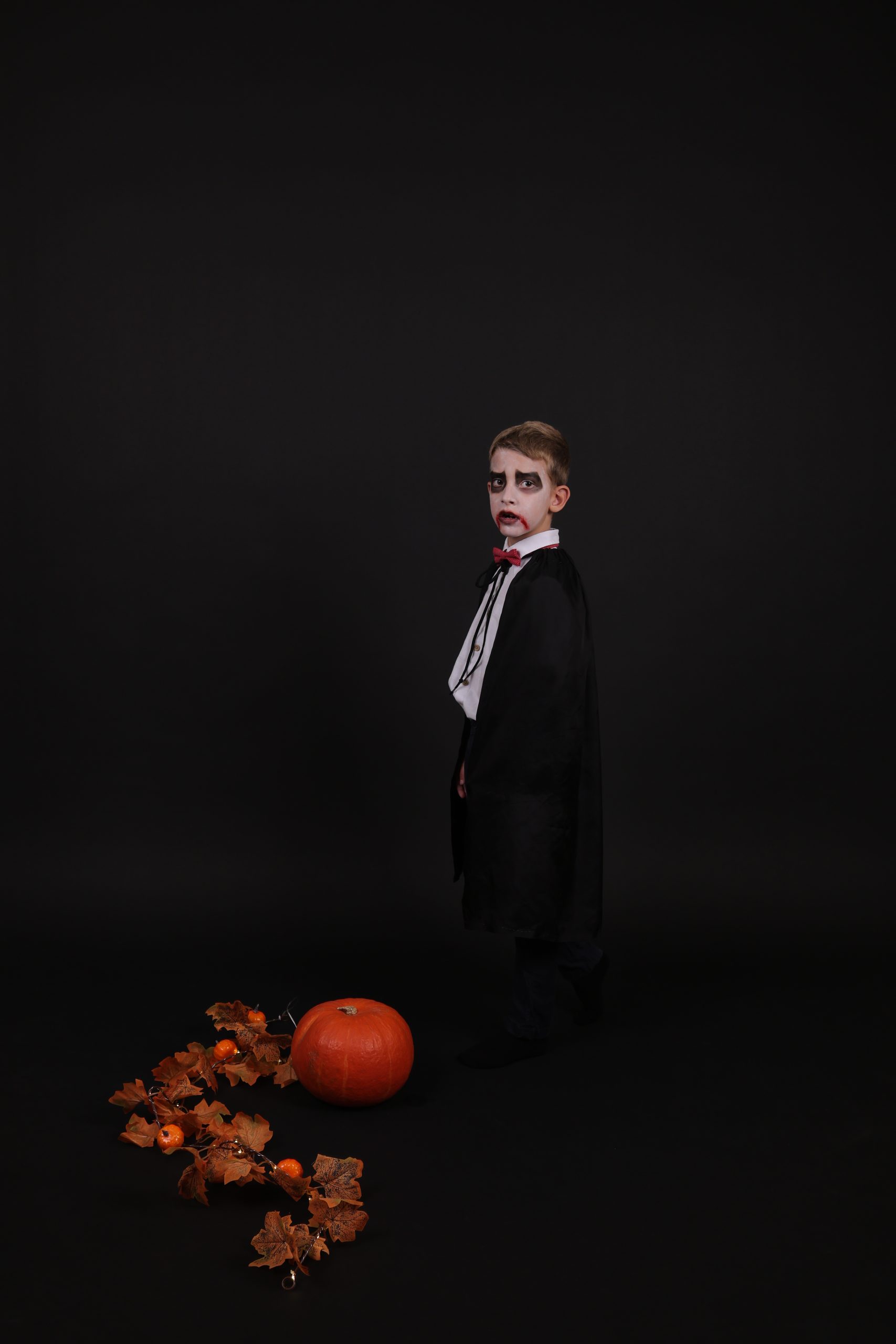 Dečak u kostimu vampira pored bundeve, Halloween foto sesija na crnoj pozadini u studiju na Novom Beogradu
