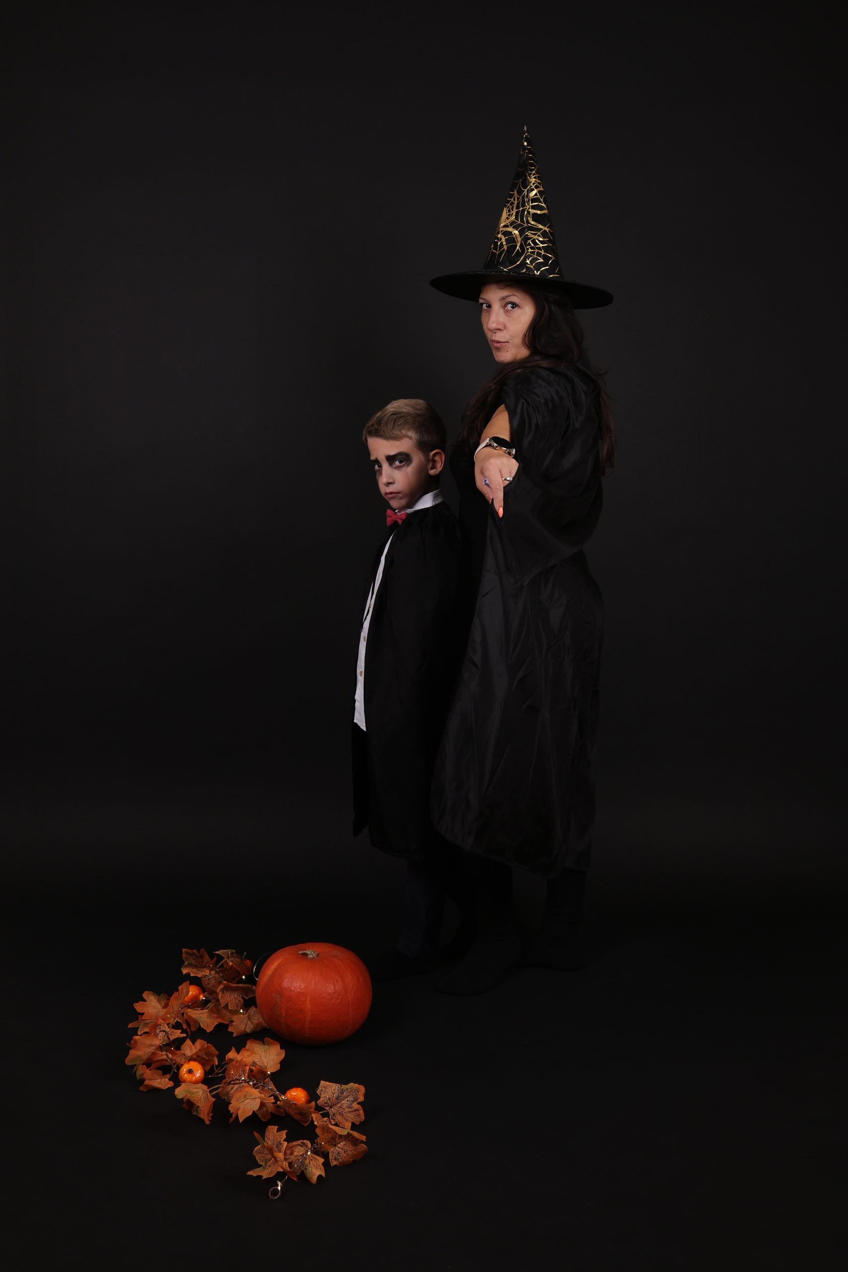 Mama i sin u kostimima veštice i vampira, porodična Halloween foto sesija u self foto studiju